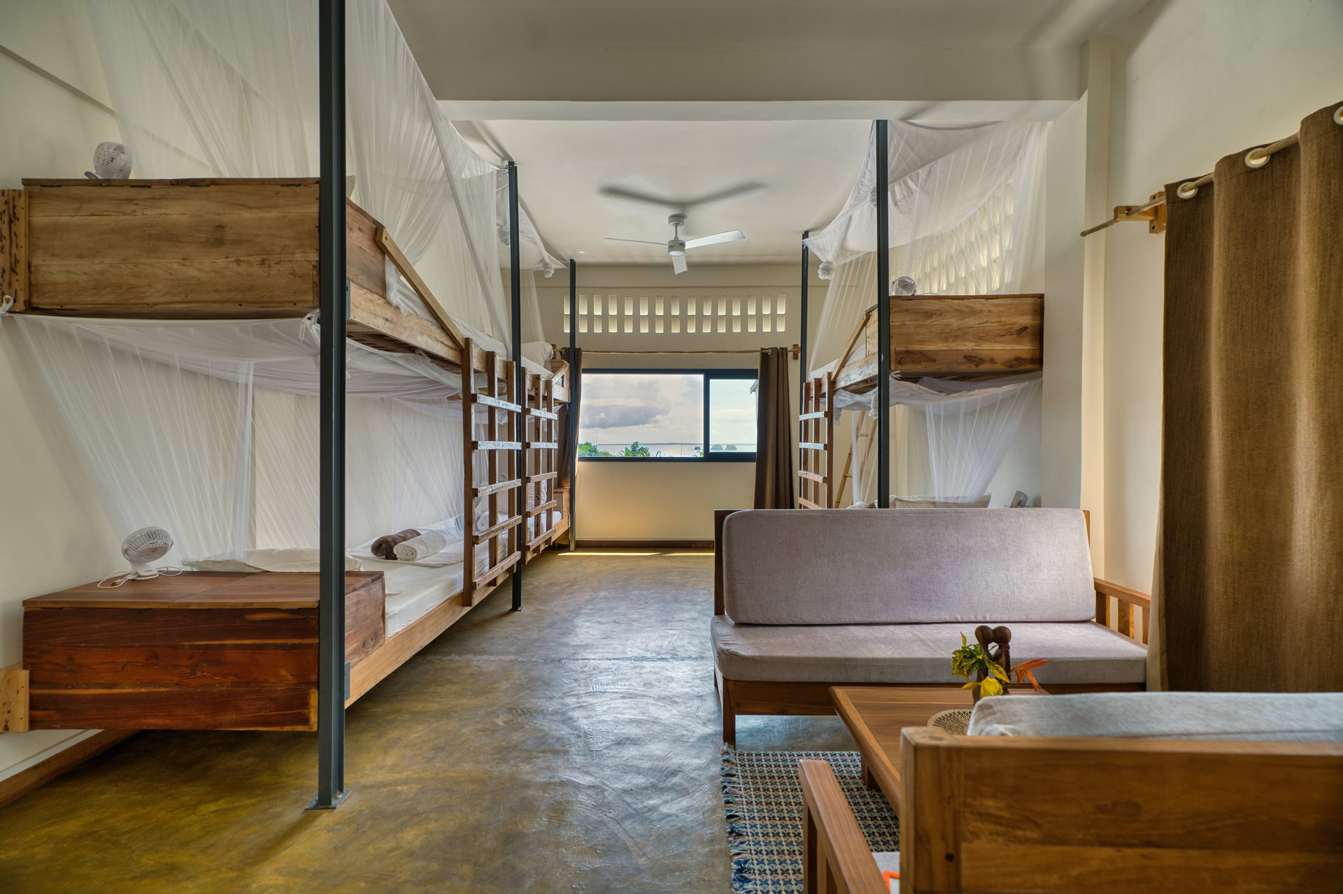 Mixed dormitory bunk beds with mosquito nets and lounge area