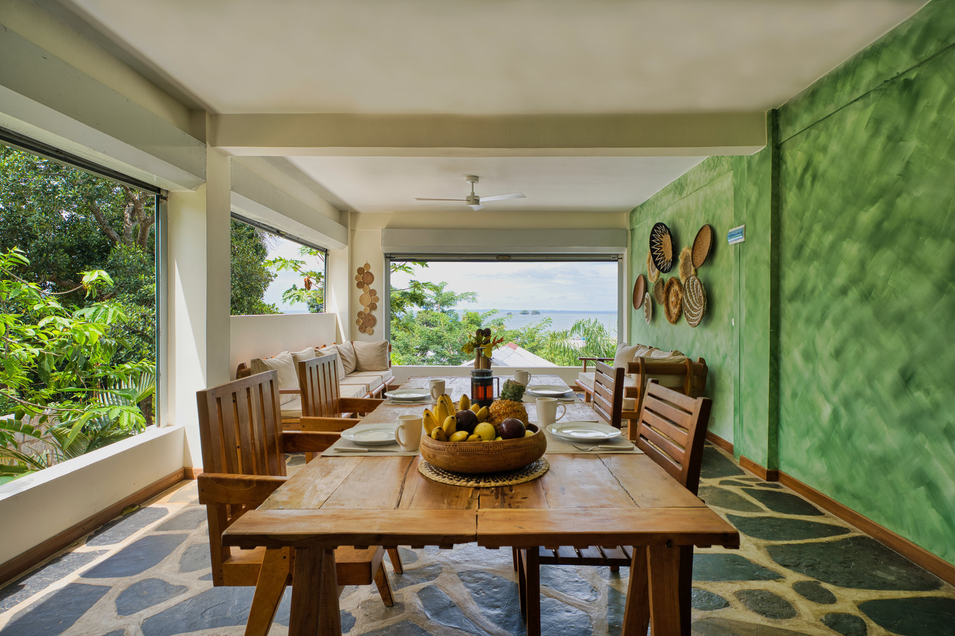 Shared dining area with tropical fruit and ocean views at Makis' Vallée